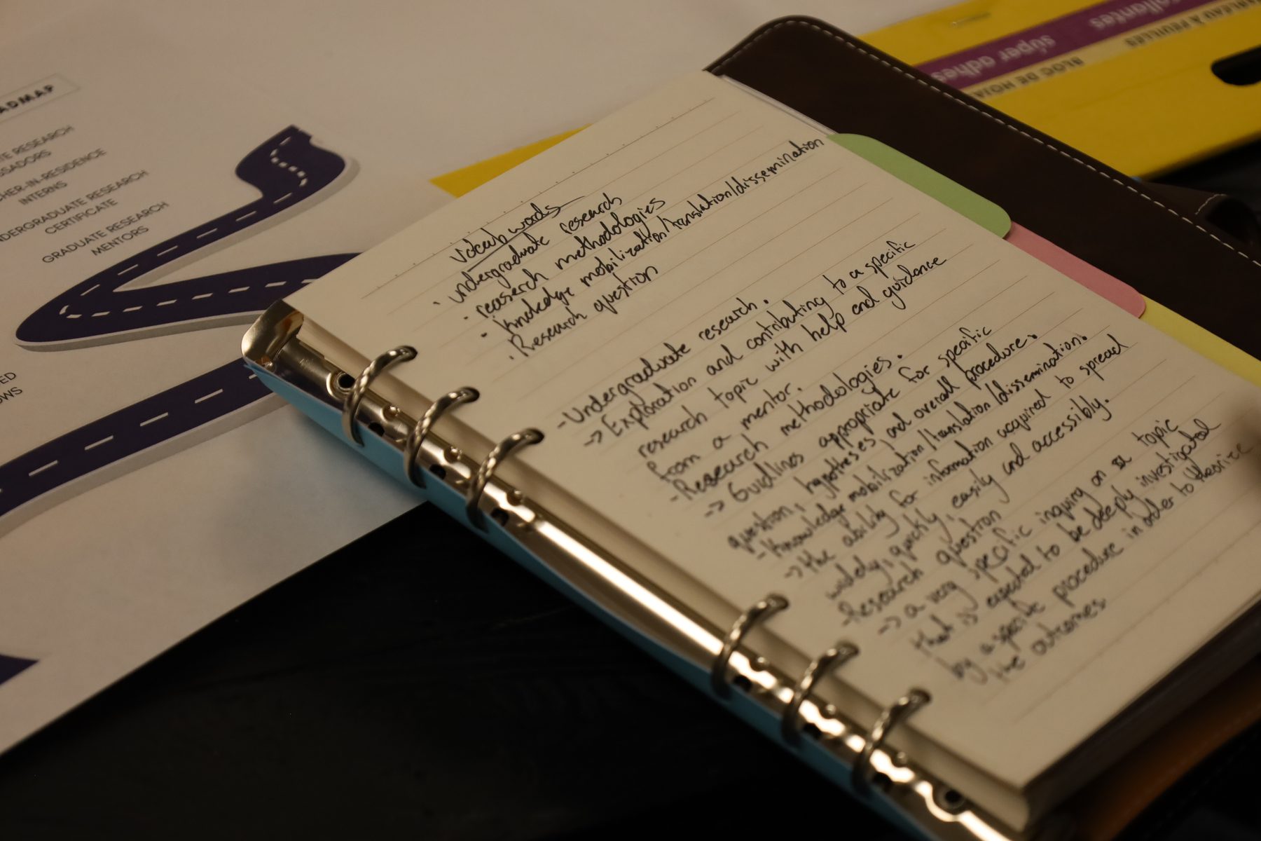 An open notebook with handwritten research plans and notes.