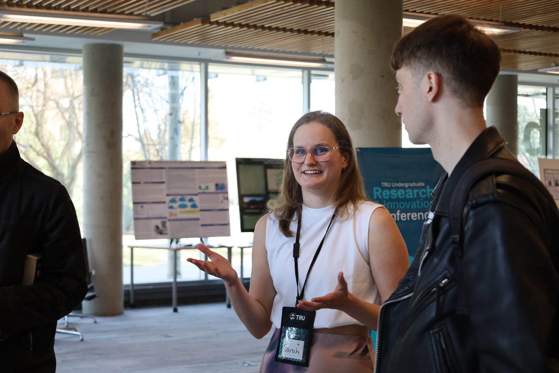 A student explains her research to a visitor at the TRU Undergraduate Research and Innovation Conference.