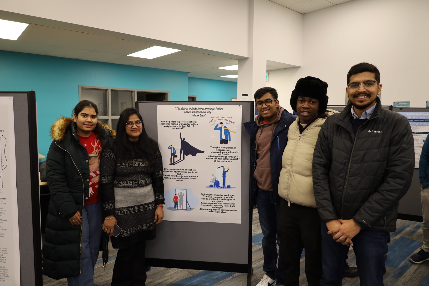 Students and faculty gather around a poster at a research showcase.