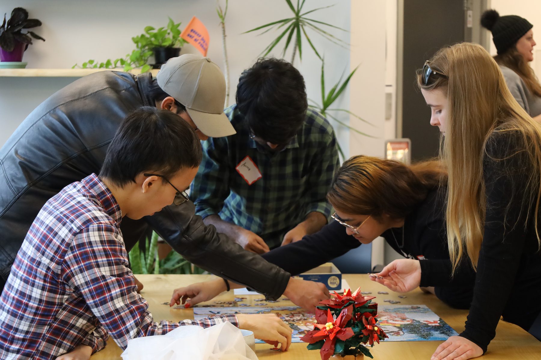 A diverse group of graduate students lean in to work on a shared task together.